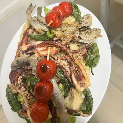 Fuente compartida con pescaíto frito, calamares, pimientos verdes y tomates cherry en brocheta